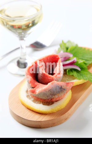 Pesce di antipasto e un bicchiere di vino bianco Foto Stock