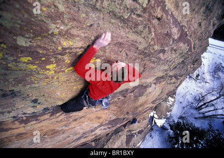 Un uomo di raggiungere per una messa in attesa mentre si portano nei pressi di arrampicata Boulder, Colorado (angolo alto punto di vista). Foto Stock