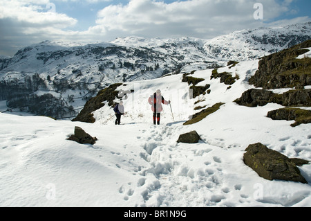 Hill walkers sul timone roccioso in inverno, Easedale, vicino a Grasmere, Lake District, Cumbria, England, Regno Unito Foto Stock
