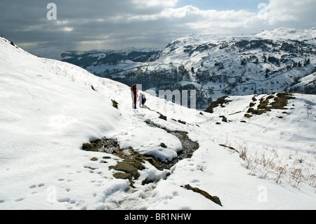 Hill walkers sul timone roccioso in inverno, Easedale, vicino a Grasmere, Lake District, Cumbria, England, Regno Unito Foto Stock