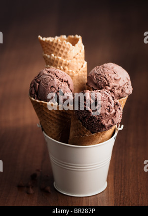 Gelato al cioccolato in coni in piedi in color crema benna in metallo Foto Stock