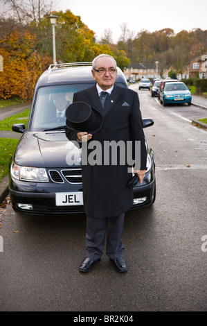 Impresario di fronte nero funebre funebre lasciando complesso residenziale a Welwyn Garden City, Hertfordshire, Inghilterra, Regno Unito Foto Stock