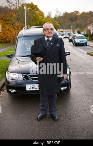 Impresario di fronte nero funebre funebre lasciando complesso residenziale a Welwyn Garden City, Hertfordshire, Inghilterra, Regno Unito Foto Stock