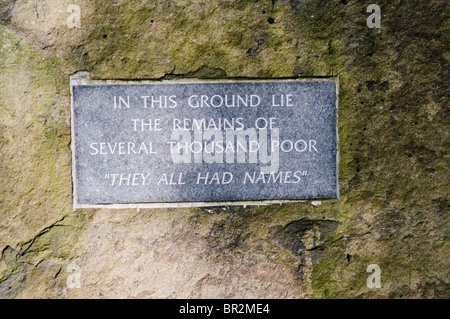 Placca su una grande pietra dicendo "In questa terra si trovano i resti di diverse migliaia di poveri. Tutti avevano nomi" Foto Stock