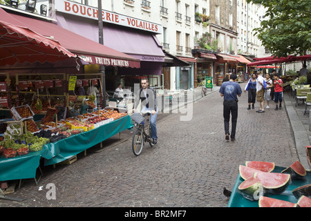 Un uomo cicli attraverso il mercato di Rue Mouffetard, una celebre mercato alimentare. Parigi Foto Stock