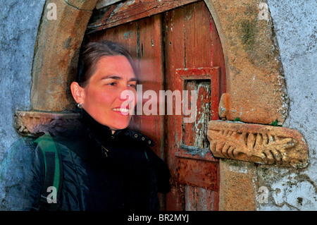 Portogallo Alentejo: Donna passando dal davanti del portale tipiche dello storico quartiere ebraico di Castelo de Vide Foto Stock