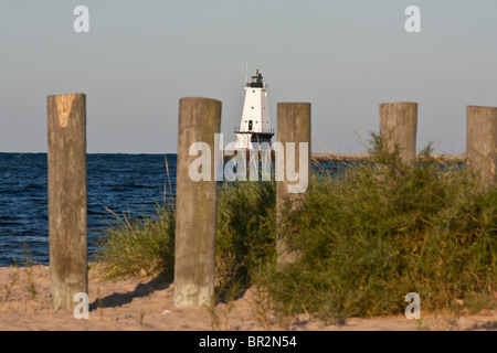 Faro bianco e fila di picchi di legno sulle spiagge sabbiose del lago Michigan, Michigan, negli Stati Uniti, grandi Laghi, nessuno paesaggio fuori dall'orizzonte ad alta risoluzione Foto Stock