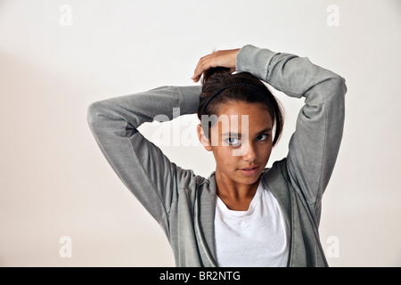 Etnicamente diversi Girl Teen 14-16 anno vecchio che indossa un maglione grigio ragazza ispanica tira i capelli indietro nella coda di cavallo. persona persone signor © Myrleen Pearson Foto Stock