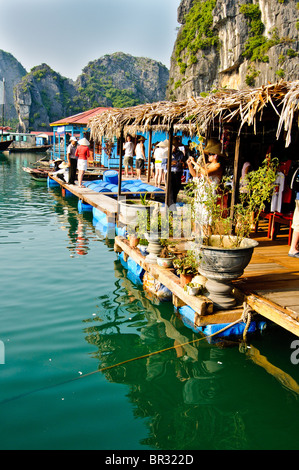I turisti in visita a un villaggio di pescatori che si trova nella baia di Halong, Vietnam Foto Stock