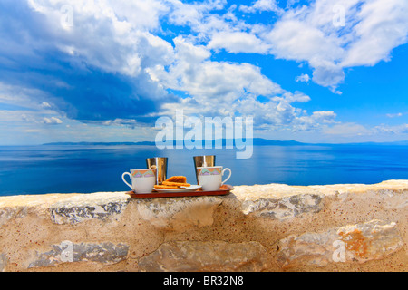 Pronto a servire le tazze di caffè e biscotti contro un cielo nuvoloso Foto Stock