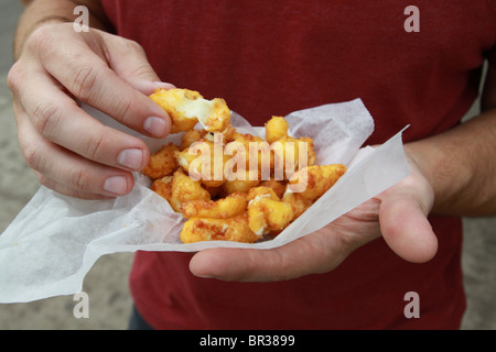 Un uomo con un serving di cagliata di formaggio presso la Minnesota State Fair. Foto Stock