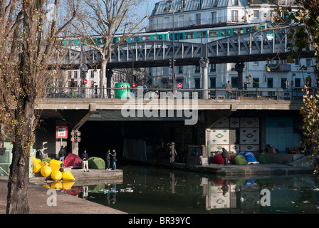 Persone senza dimora che vivono in tende lungo il Canal Saint Martin sotto stalingrad stazione della metro di Parigi. Francia Foto Stock