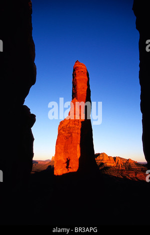 Una persona di ombra catturati nella metà di saltare su di una roccia rossa guglia a Sedona, in Arizona, al tramonto Foto Stock