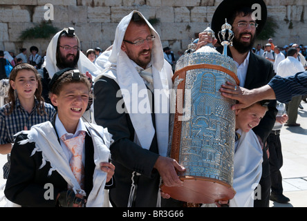 Ragazzo che porta rotolo di Torah durante il bar mitsva cerimonia al muro occidentale. Gerusalemme Foto Stock