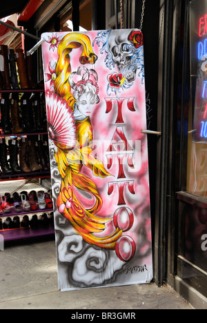 Segno colorato al di fuori di un salone per tatuaggi Foto Stock