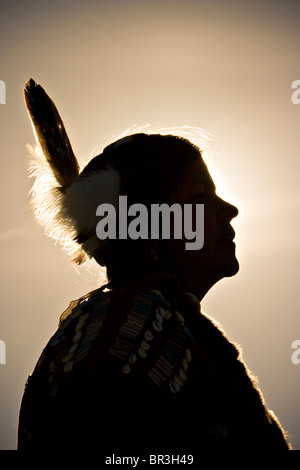 Un nativo americano in abito tradizionale visto in silhouette in un powwow in Post caduta, Idaho. Foto Stock
