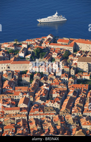 DUBROVNIK, Croazia. Uno yacht di lusso vela oltre le mura della città vecchia, all'alba. 2010. Foto Stock