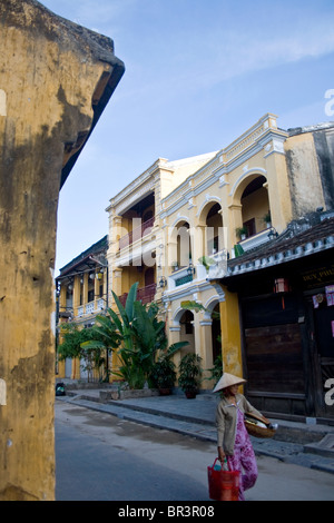 Una donna che cammina in Hoi An strade mattina presto Foto Stock