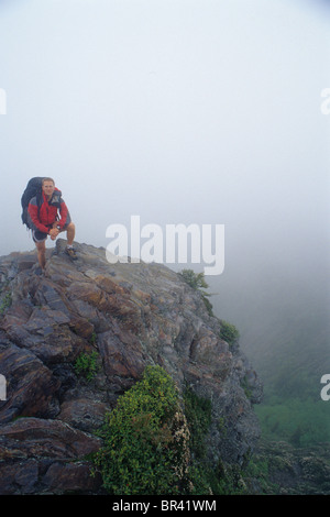 Backpacker maschio si erge tra le nuvole in cima Charlie's Bunion lungo l'Appalachian Trail di Great Smoky Mountains Foto Stock