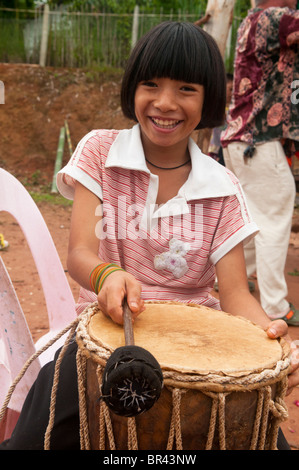 Sorridente ragazza Akha tamburi al festival nel nord della Thailandia Foto Stock