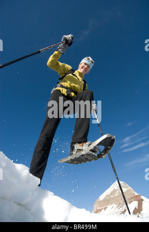 Donna con le racchette da neve sotto la montagna, San Juan National Forest, Colorado. Foto Stock