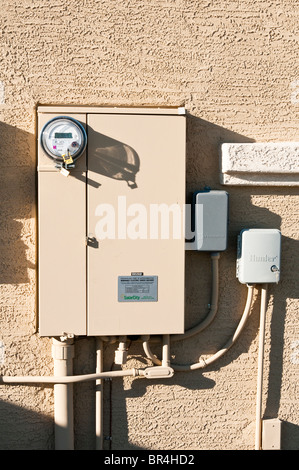 La circuiteria di interconnessione racchiusi in pannelli elettrici collegare l'energia solare per fonti convenzionali sul lato di una casa. Foto Stock