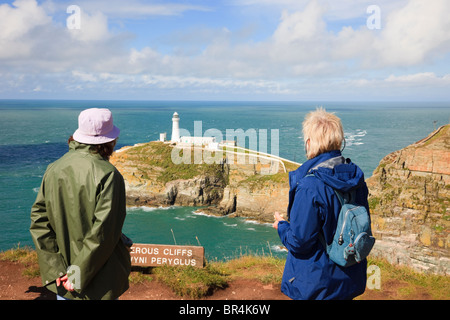 Sud Stack, Isola di Anglesey, Galles del Nord, Regno Unito. Due donne turisti sulla cima delle scogliere guardando la vista al faro Foto Stock