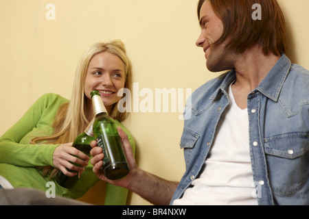 Coppia giovane la tostatura con bottiglie di birra Foto Stock