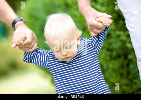 Nonni camminando mano nella mano toddler Foto Stock