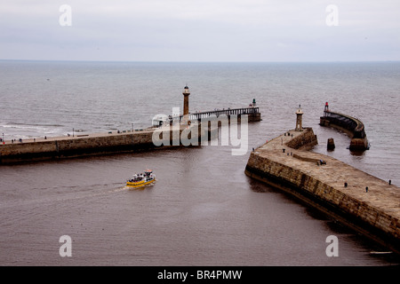 Una nave che lascia il porto a Whitby, North Yorkshire, Inghilterra. Foto Stock