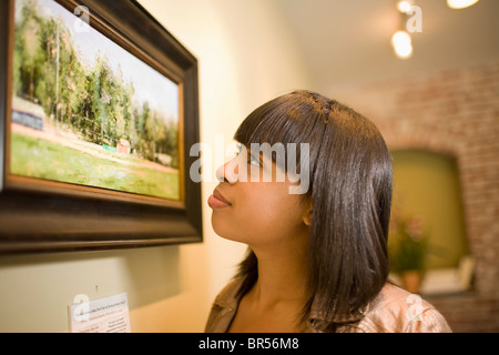 Razza mista donna ammirando la pittura in galleria Foto Stock