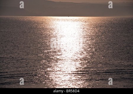 Il sole tramonta sul mare sulla costa est del North Yorkshire, Whitby. Foto Stock