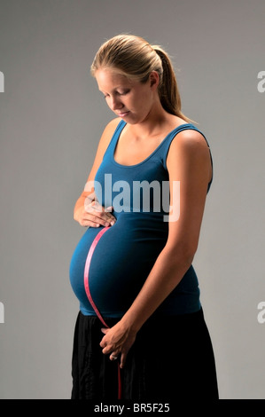 Donna incinta con il tame misurare Foto Stock
