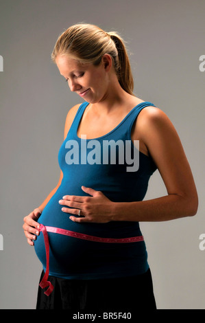 Donna incinta con il tame misurare Foto Stock