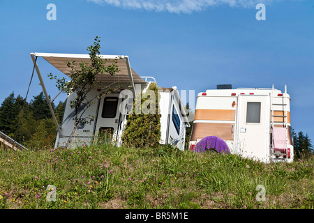 Due RVs parcheggiato in posizione idilliaca sulla cima di un promontorio coperto con erbe selvatiche & fiori e affacciato sulla Baia di Clallam in Sekiu Washington Foto Stock