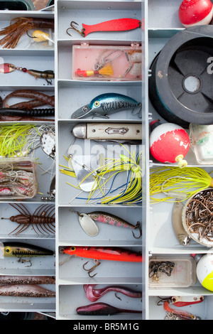 Un fornitissimo fishermans tackle box completamente rifornito con esche e ingranaggio per la pesca. Foto Stock