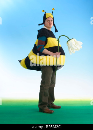 Uomo in divertente costume da ape azienda fiore appassito Foto stock - Alamy