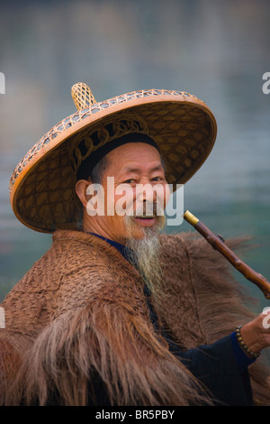 Fisherman indossando la paglia di rivestimento tubo di fumo sul Fiume Li e Yangshuo, Guangxi, Cina Foto Stock