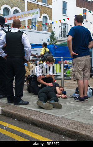 La polizia che frequentano a qualcuno che è collassato al 2009 carnevale di Notting Hill Foto Stock