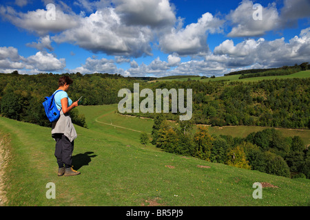 Donna rambler la lettura di una mappa sulla South Downs. Foto Stock