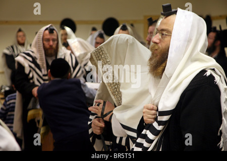 Ebrea ortodossa appartenenti agli uomini il Bobov Hasidism durante la preghiera del mattino all'interno di un Stamford Hill sinagoga. Foto Stock