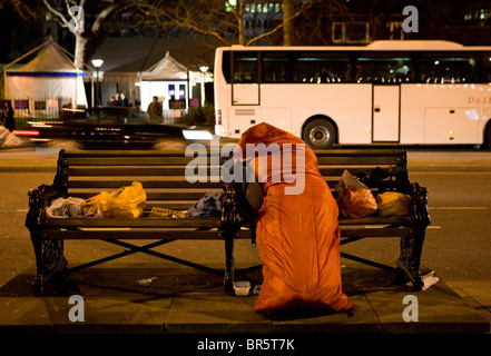 Un senzatetto donna dorme nel suo sacco a pelo su Victoria Embankment, Londra. Foto Stock