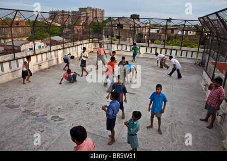 I bambini giocano a calcio sul tetto del CINI casa a metà strada per la vulnerabilità dei bambini di strada di Calcutta, in India. Foto Stock