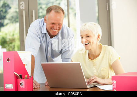 Figlio di adulti e Senior madre utilizzando portatile a casa Foto Stock