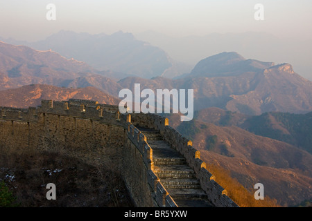 La Grande Muraglia di avvolgimento in montagna al tramonto, Jinshanling, Hebei, Cina Foto Stock