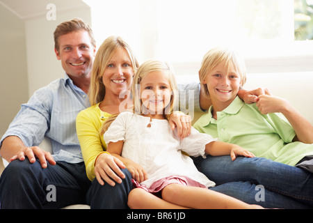 Ritratto di giovane famiglia rilassante insieme sul divano Foto Stock