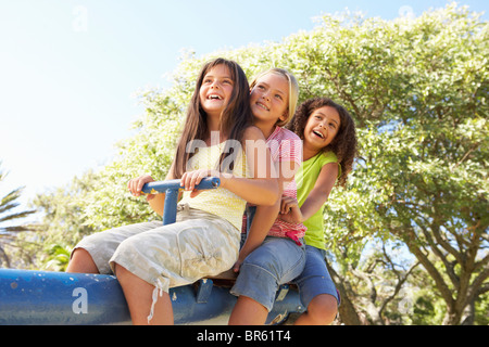 Le tre ragazze a cavallo di vedere visto nel parco giochi Foto Stock