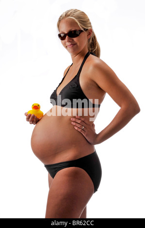 Donna incinta con puntelli e Black costume da bagno su sfondo bianco. Foto Stock