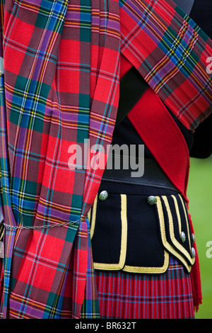 Uomo che indossa Royal Stewart plaid: tartan scozzese Highland abito vestito a Braemar Highland Games o raccolta, Aberdeenshire, Scotland, Regno Unito Foto Stock