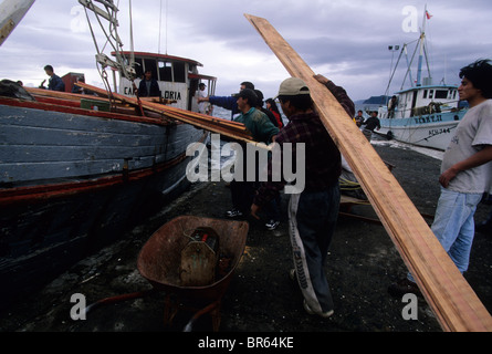 Caricamento di una barca di legno sul giorno di mercato in Achao Isla Quinchao arcipelago di Chiloe Cile Foto Stock